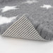close up of Profleece pet vet bedding grey with white stars, the corner lifted up to show the non slip backing